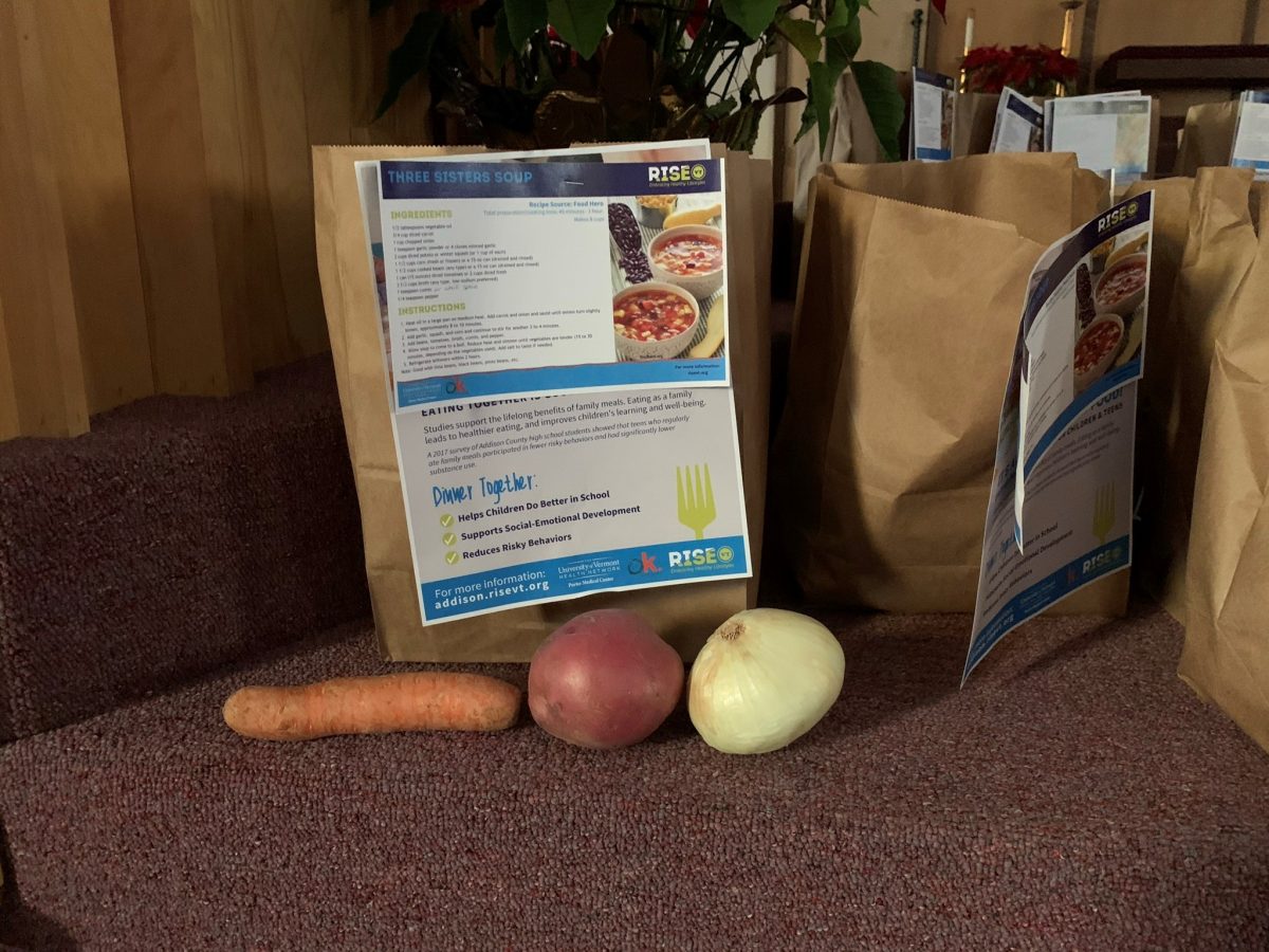 A photograph of a Rise Vermont Meal Kit - food in a bag and a Rise Vermont recipe card is attached to the bag.